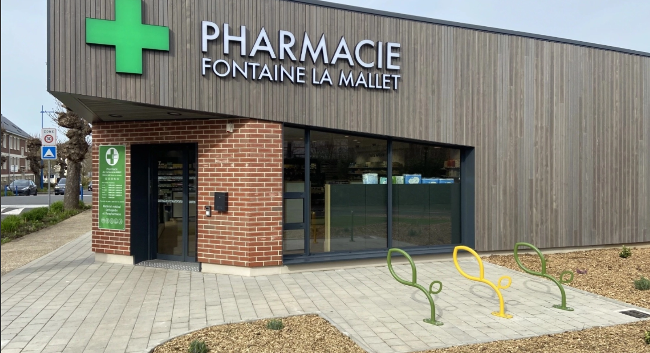 Pharmacie de Fontaine La Mallet avec bornes pour accrocher les vélos en forme de feuille de différentes couleurs